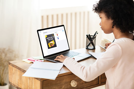 A girl working at her laptop and making her assignment